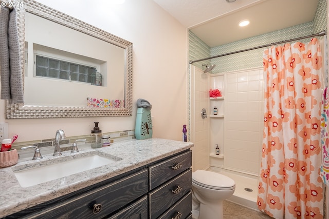 bathroom featuring toilet, vanity, and a shower with shower curtain