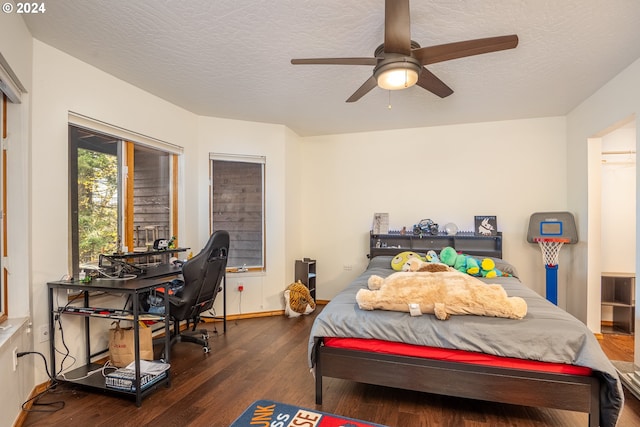 bedroom featuring ceiling fan, dark hardwood / wood-style flooring, and a textured ceiling