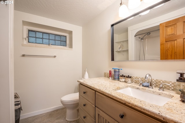 bathroom featuring vanity, a shower, tile patterned floors, toilet, and a textured ceiling