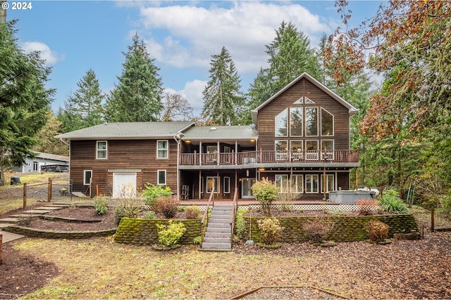 rear view of house with a hot tub and a deck