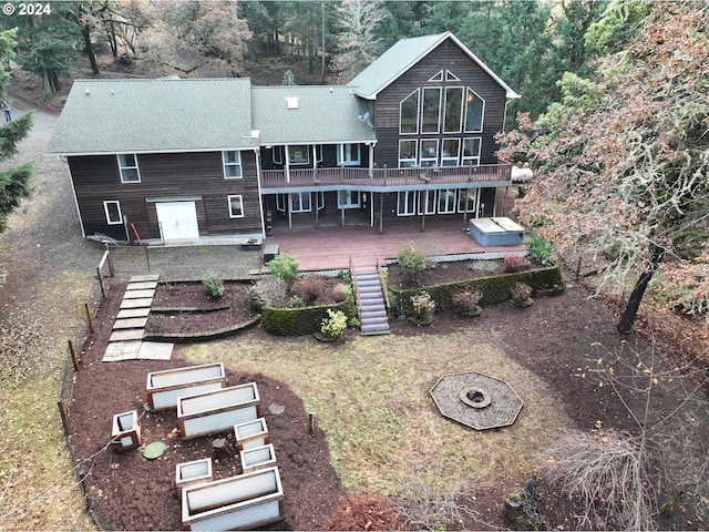 back of property featuring a fire pit and a wooden deck