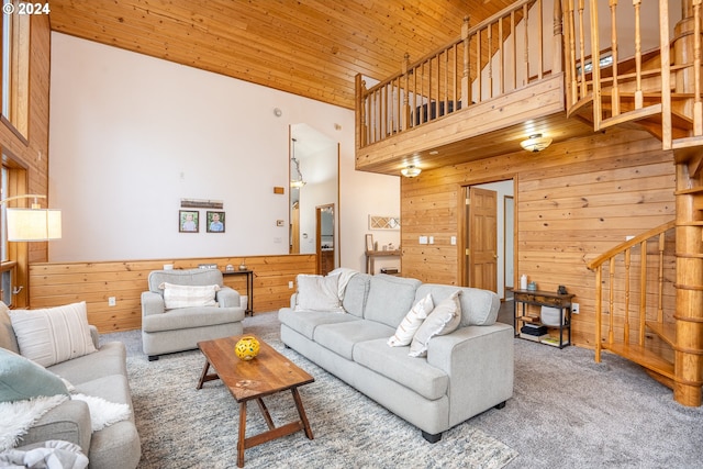 carpeted living room with wooden walls, high vaulted ceiling, and wooden ceiling