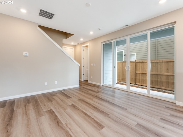 unfurnished room featuring light wood-type flooring and a healthy amount of sunlight