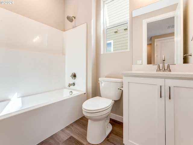 full bathroom featuring hardwood / wood-style floors, vanity, toilet, and bathtub / shower combination