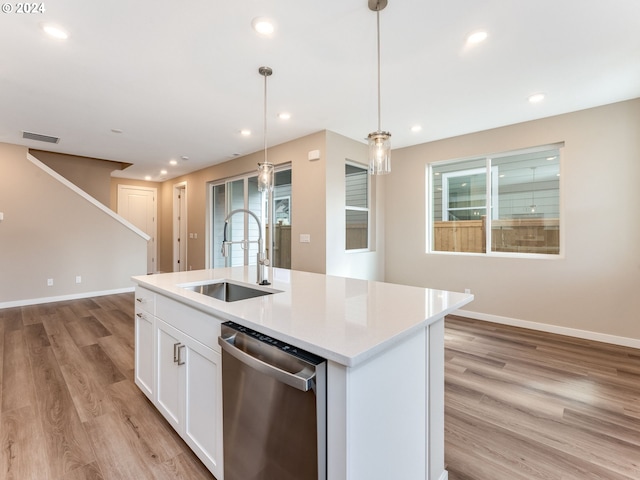 kitchen with white cabinetry, sink, stainless steel dishwasher, an island with sink, and decorative light fixtures