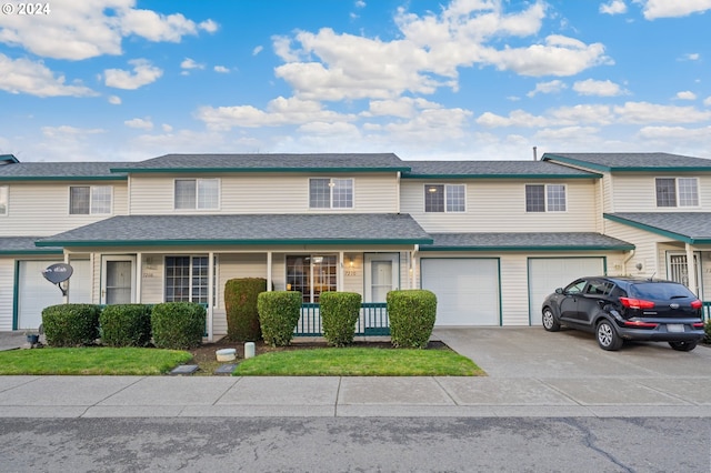 townhome / multi-family property featuring a porch and a garage