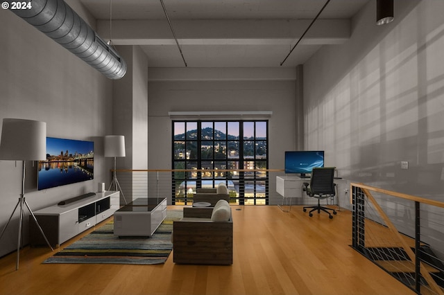 living area featuring a towering ceiling and wood finished floors