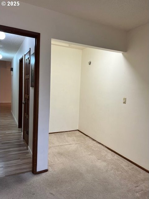 carpeted empty room with a textured ceiling