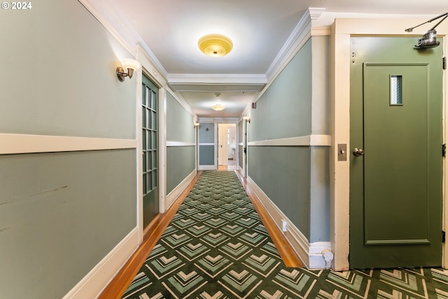 corridor featuring ornamental molding and dark colored carpet