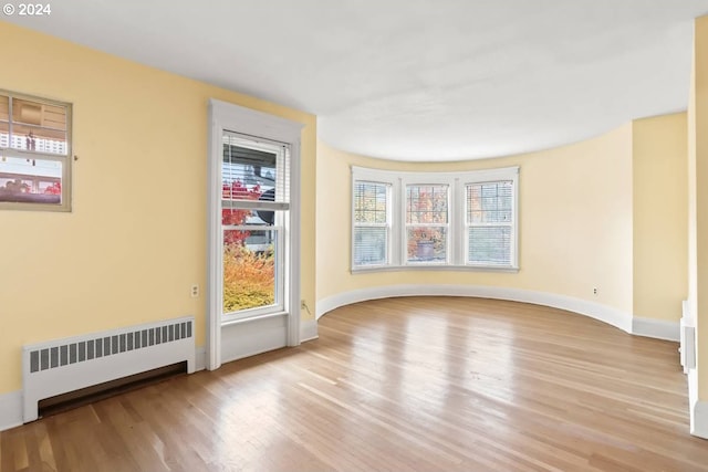 spare room with radiator, light hardwood / wood-style floors, and plenty of natural light