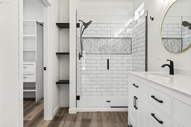 6018 Little Woahink Dr, Florence, OR 97439 - full bathroom featuring a stall shower, vanity, wood finished floors, a spacious closet, and built in shelves