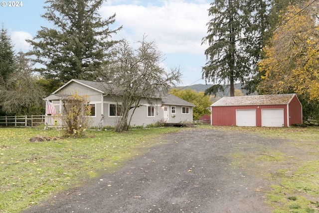 view of front facade with an outbuilding, a garage, and a front yard