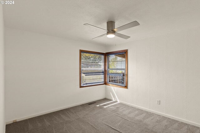 empty room featuring ceiling fan and carpet floors