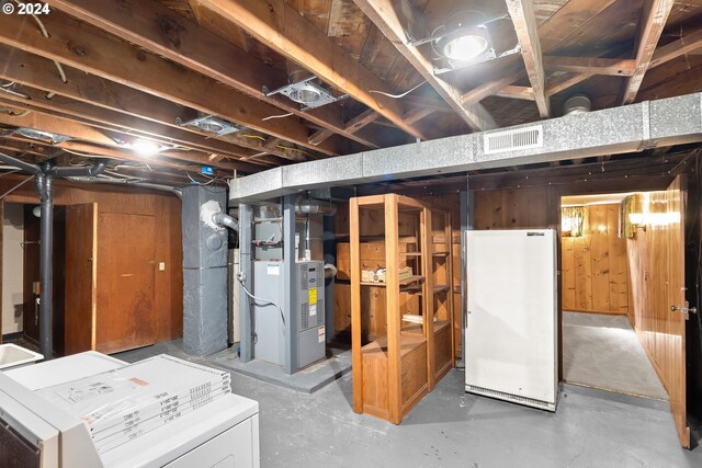 basement with white fridge and heating unit