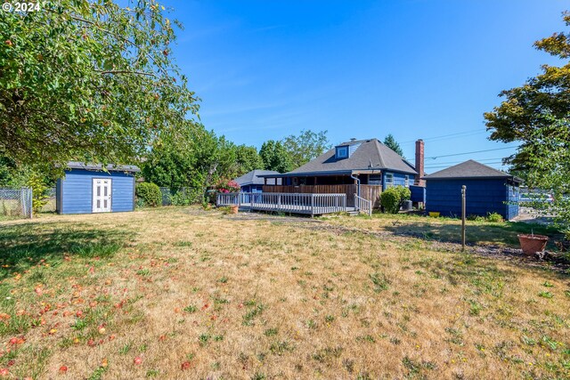 view of yard with a wooden deck and a storage unit