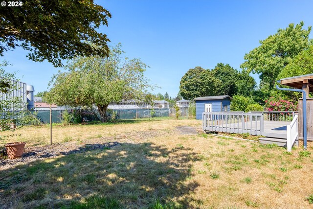 view of yard featuring a storage shed and a wooden deck