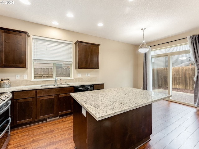 kitchen with sink, a center island, hanging light fixtures, light hardwood / wood-style flooring, and stainless steel range with electric stovetop