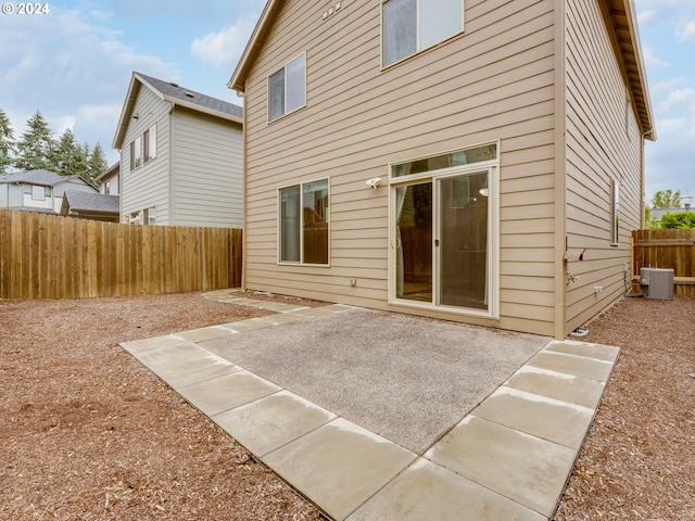 back of property with central air condition unit and a patio