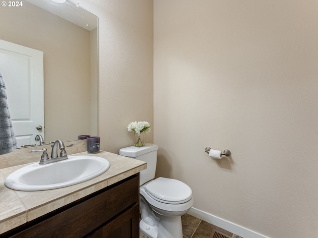 bathroom with tile patterned flooring, vanity, and toilet