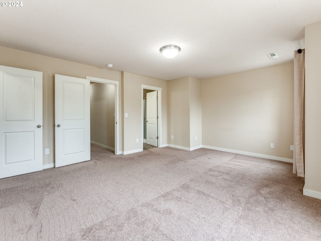 unfurnished bedroom featuring light carpet