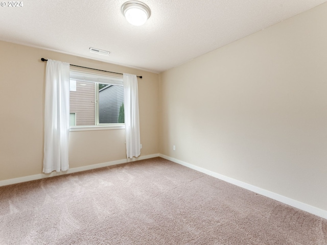 carpeted spare room with a textured ceiling