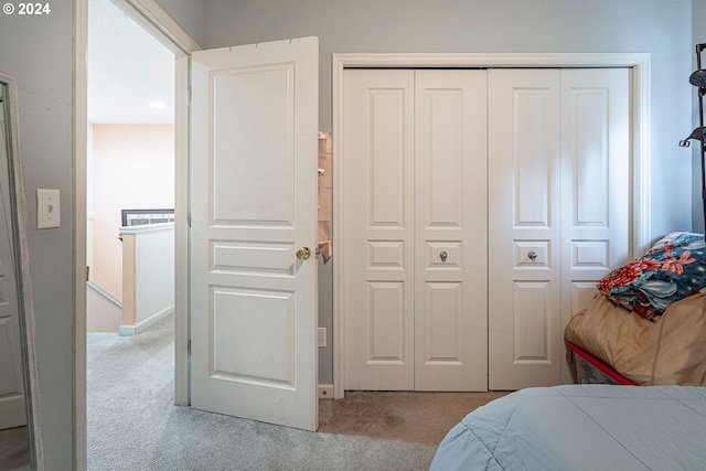 bedroom with light carpet and a closet