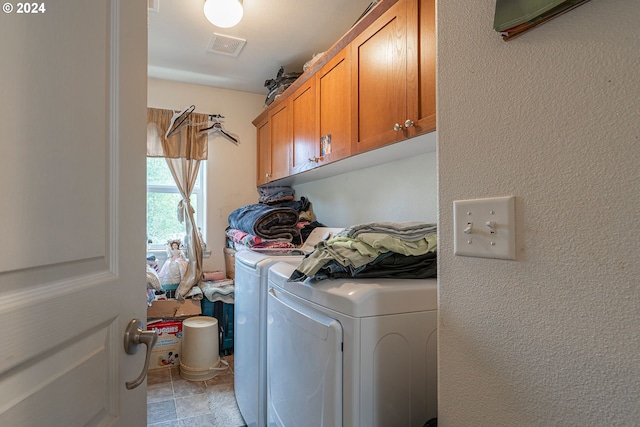 washroom featuring cabinets and washer and dryer