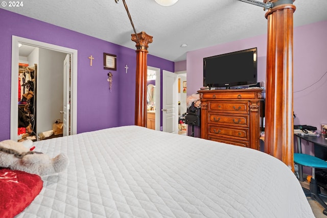 bedroom featuring a textured ceiling and ensuite bath