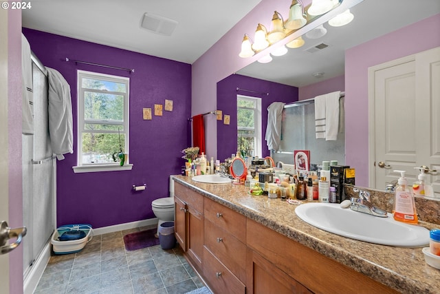 bathroom featuring toilet, a shower with door, and vanity