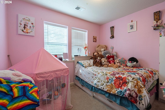 bedroom featuring light carpet and a textured ceiling