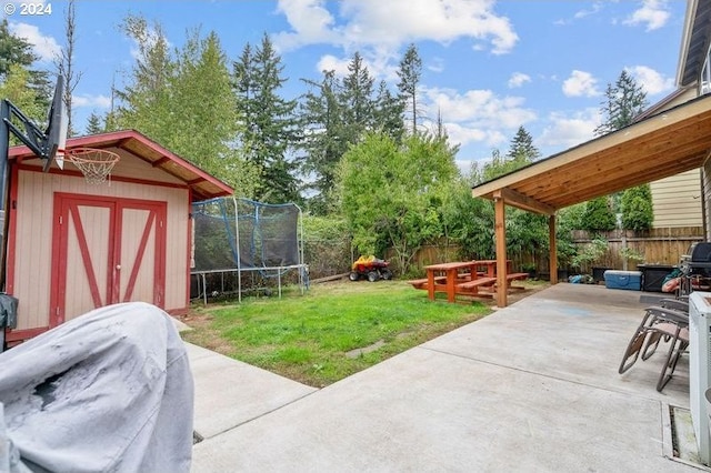 view of patio with a trampoline and a storage unit