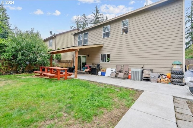 rear view of house featuring a lawn and a patio area