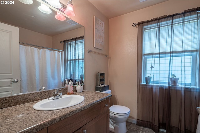 bathroom featuring tile patterned floors, vanity, and toilet