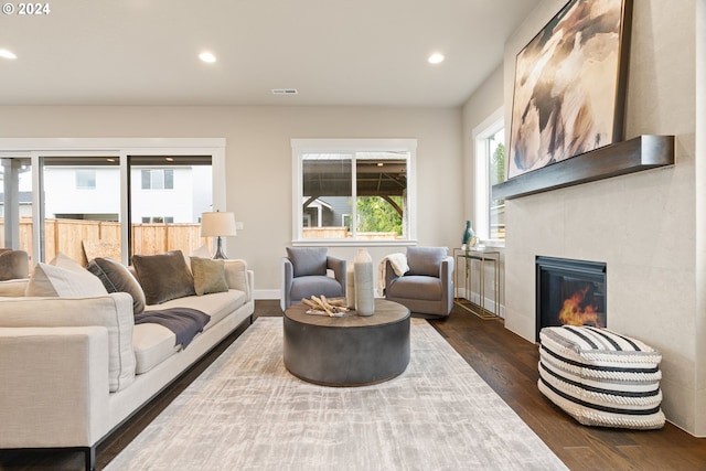 living area featuring recessed lighting, a large fireplace, dark wood-type flooring, visible vents, and baseboards