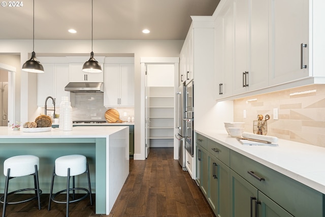 kitchen with pendant lighting, dark wood-type flooring, green cabinets, decorative backsplash, and white cabinetry