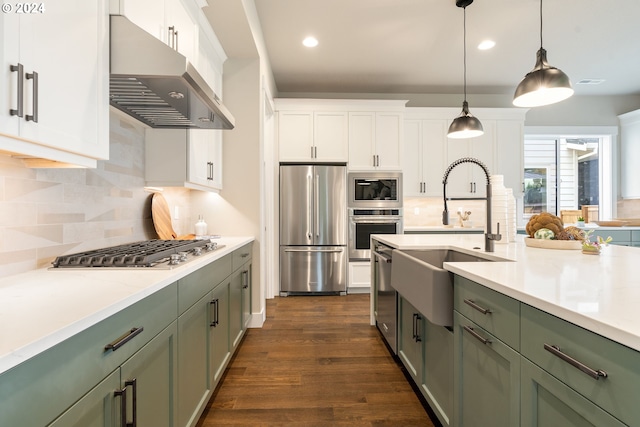 kitchen featuring stainless steel appliances, white cabinets, a sink, and wall chimney exhaust hood