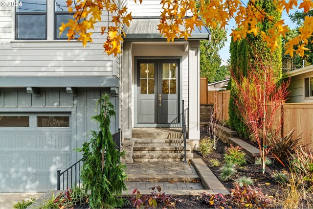 property entrance featuring a garage and french doors