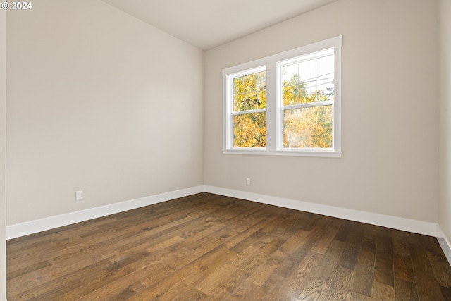 empty room with dark wood-type flooring and baseboards