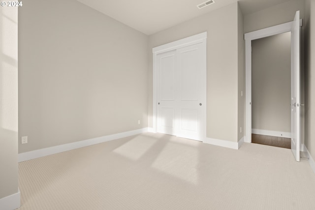 unfurnished bedroom with carpet floors, visible vents, and baseboards