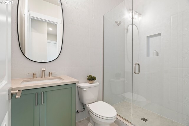 bathroom with an enclosed shower, vanity, and toilet