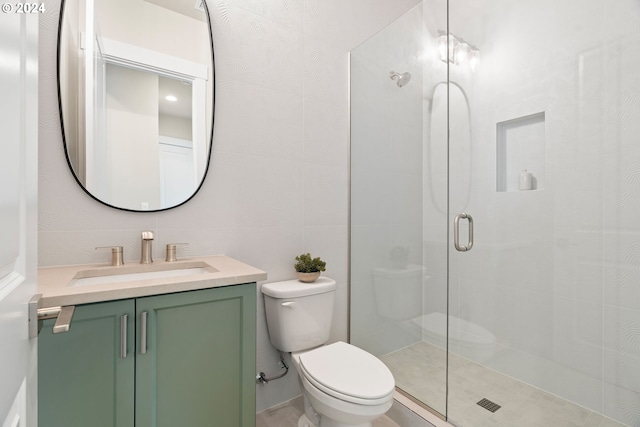 full bathroom featuring a stall shower, tile walls, vanity, and toilet