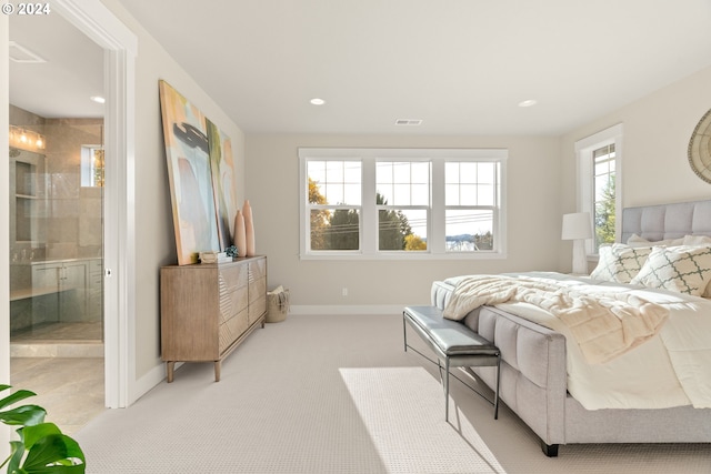 bedroom with recessed lighting, visible vents, ensuite bathroom, light carpet, and baseboards