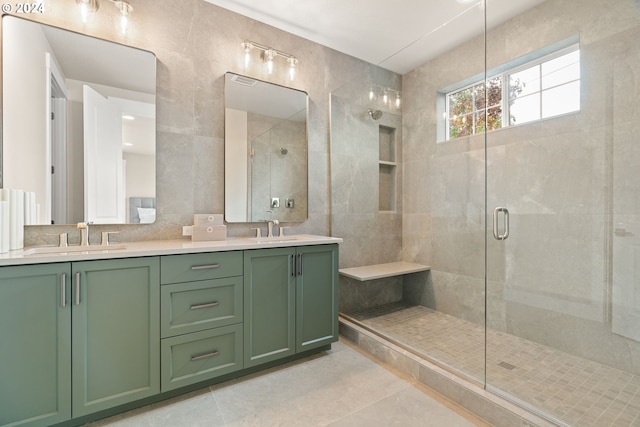 bathroom featuring tile patterned flooring, vanity, an enclosed shower, and tile walls