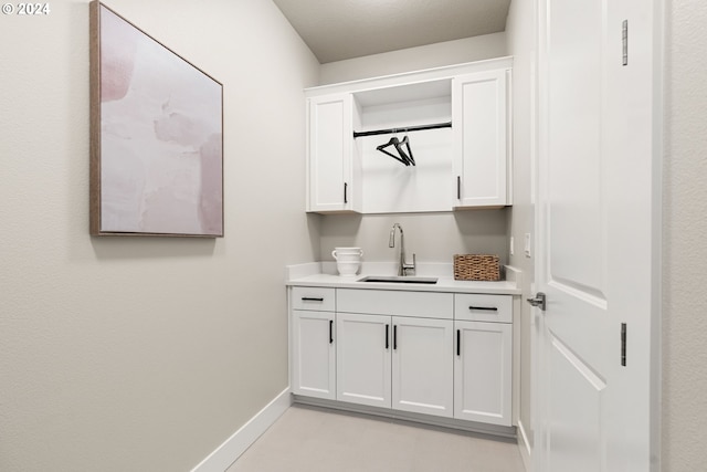 bar with a sink and baseboards