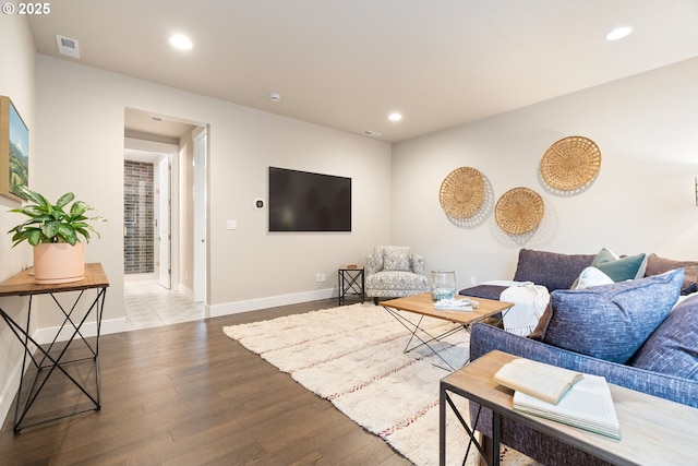 living area with baseboards, visible vents, wood finished floors, and recessed lighting