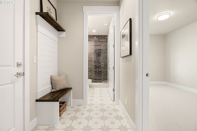 mudroom featuring light floors and baseboards