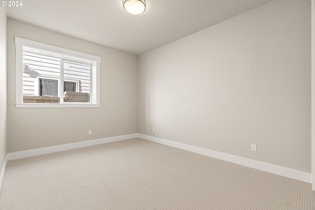 carpeted spare room with baseboards