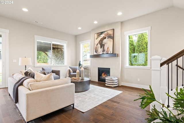 living room featuring a fireplace, hardwood / wood-style flooring, and vaulted ceiling