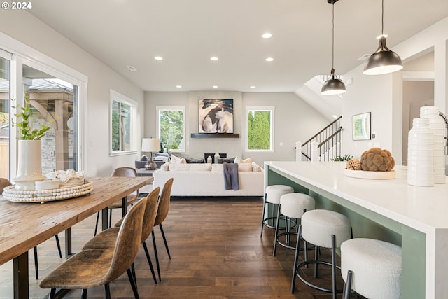 dining space with dark hardwood / wood-style flooring and a large fireplace