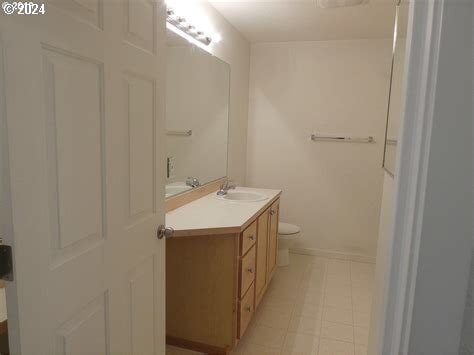 bathroom with oversized vanity, toilet, and tile flooring